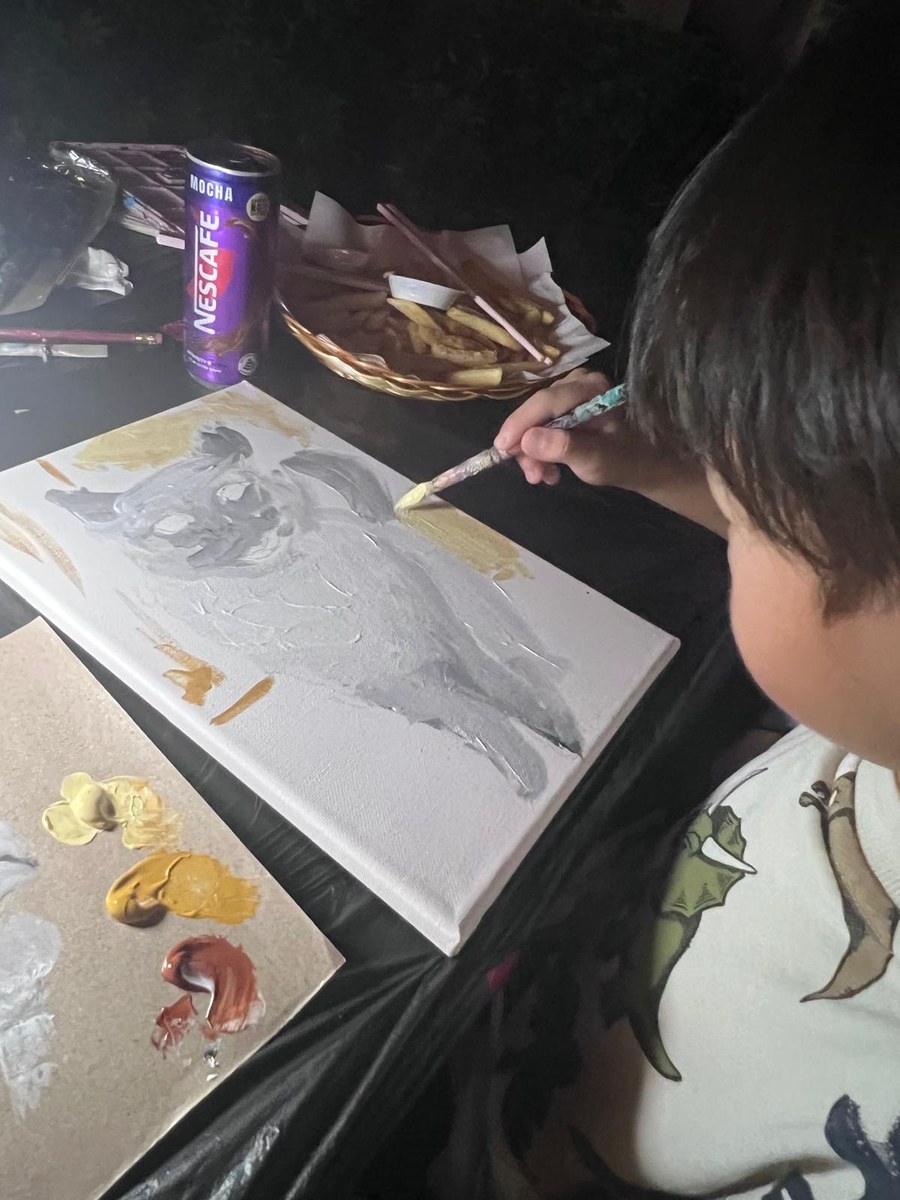 A young artist painting his pet's portrait on canvas at a stART Studio art jam
