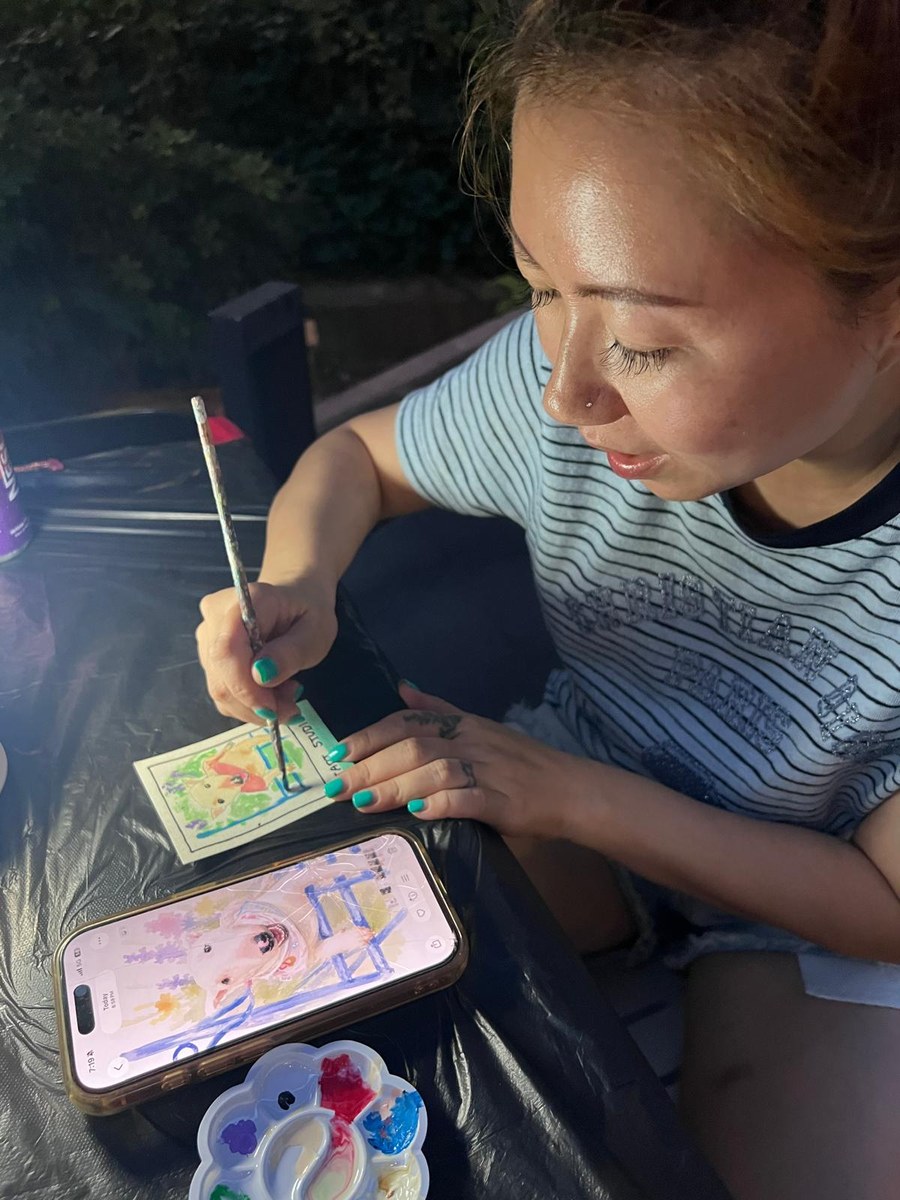 An artist painting a mini pet portrait from a photo at a stART Studio art jam