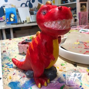 Student figurine painting of a dinosaur figurine