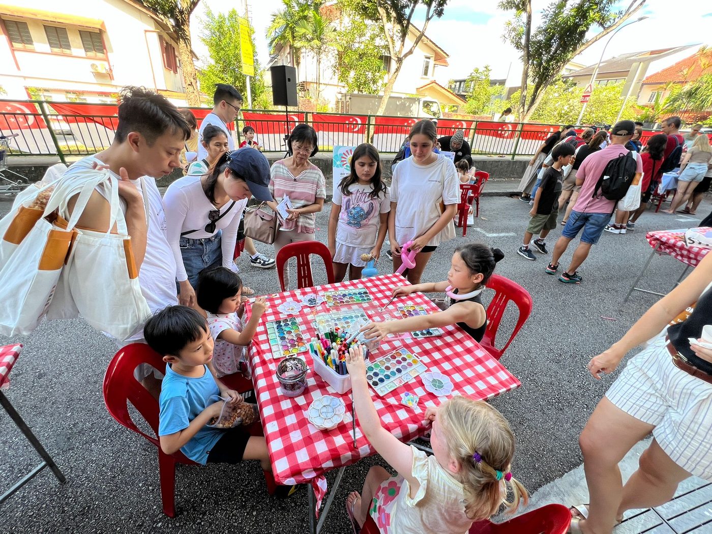 Families painting side by side at a stART Studio outdoor art jam