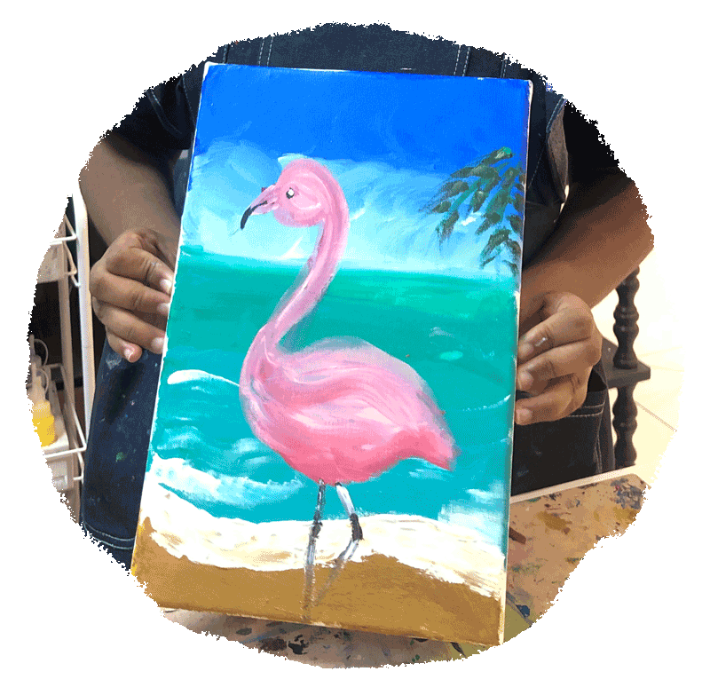 A young artist holding up the flamingo canvas she chose to paint